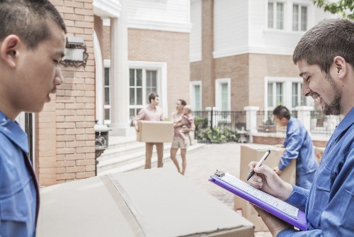 Professional movers carrying furniture through a Brixton apartment building